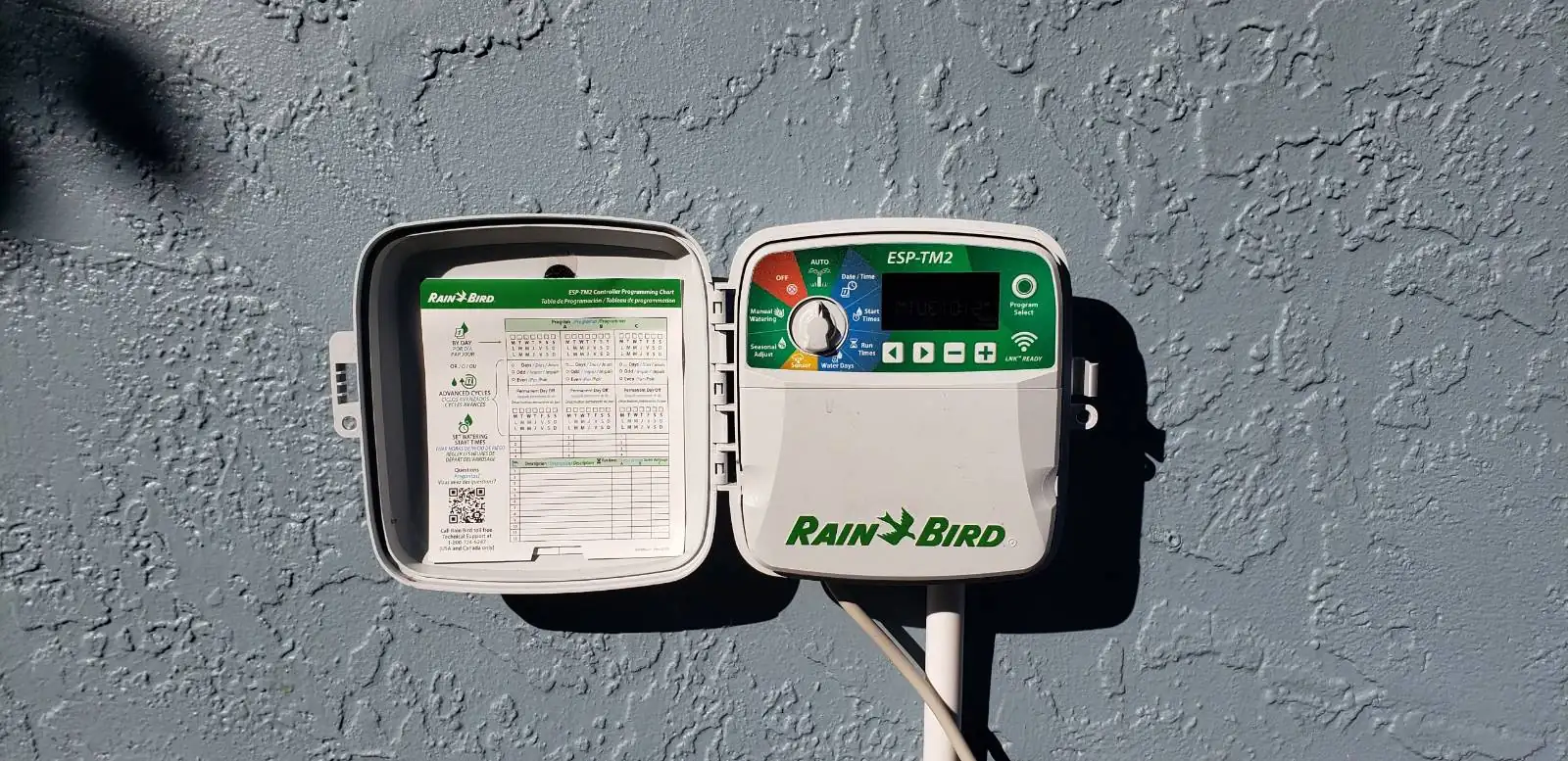 Rain Bird irrigation controller mounted on a house wall